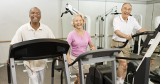 Is Sitting Too Much Bad for Your Brain? Picture of an elderly black male, an elderly caucasian female, and an elderly caucasian male all walking while on treadmills.